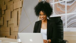 en kvinna som ler framför sin dator